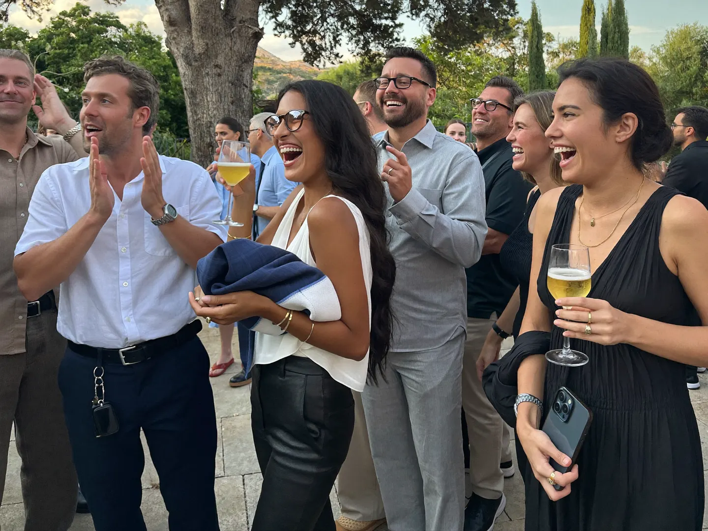Compañeros aplauden en una fiesta de empresa en un patio